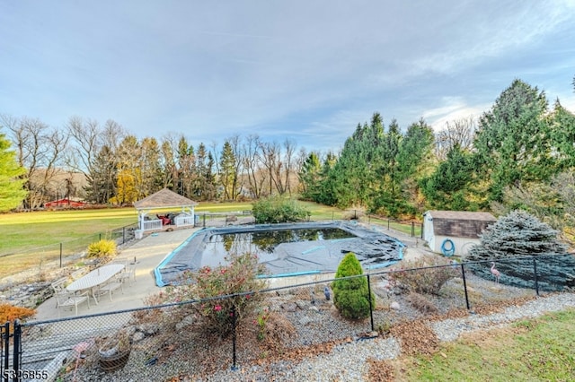 view of swimming pool featuring a gazebo, a patio area, and a shed