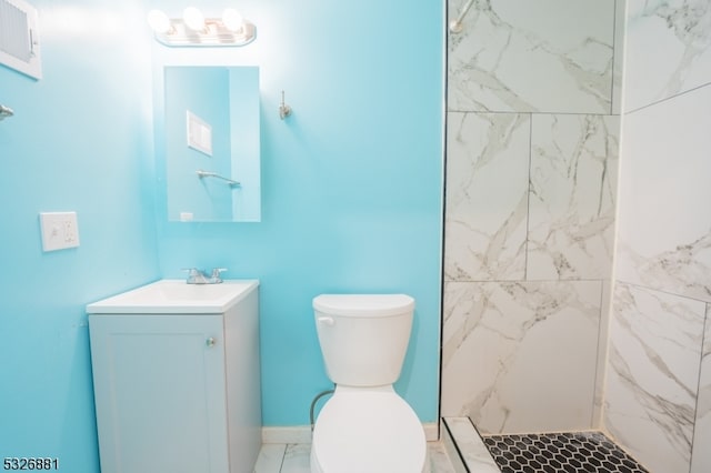 bathroom featuring tiled shower, vanity, and toilet