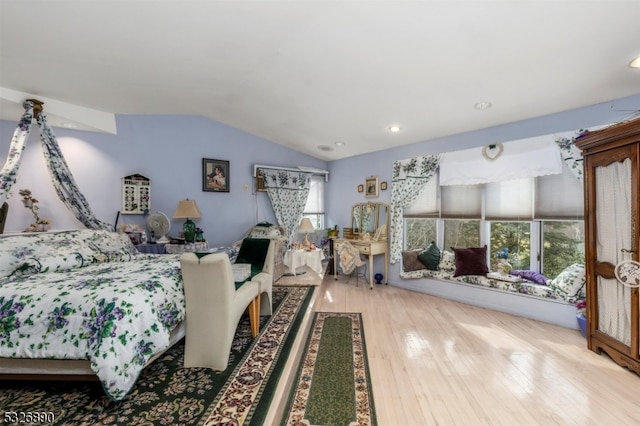 bedroom featuring light wood-type flooring and vaulted ceiling