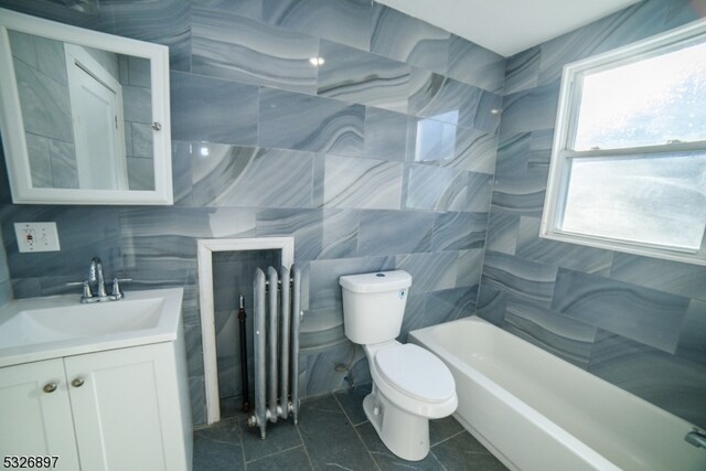 bathroom featuring vanity, radiator, tile patterned flooring, toilet, and tile walls