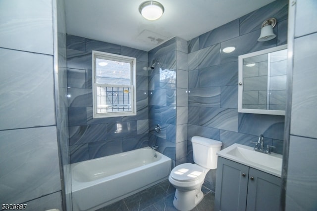 full bathroom with toilet, decorative backsplash, vanity, tile walls, and tiled shower / bath