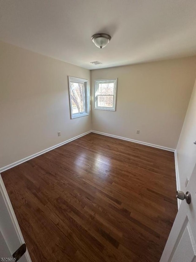 spare room with dark hardwood / wood-style flooring