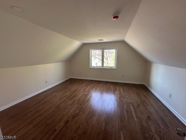 additional living space with dark hardwood / wood-style floors and lofted ceiling