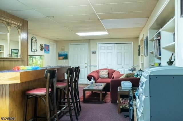 interior space with carpet flooring and a drop ceiling