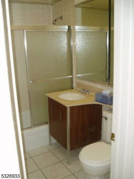 full bathroom with tile patterned floors, vanity, enclosed tub / shower combo, and toilet