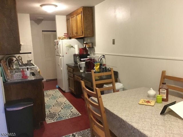 kitchen with tasteful backsplash and white fridge