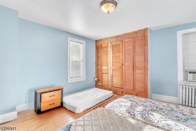 bedroom with wood-type flooring and radiator