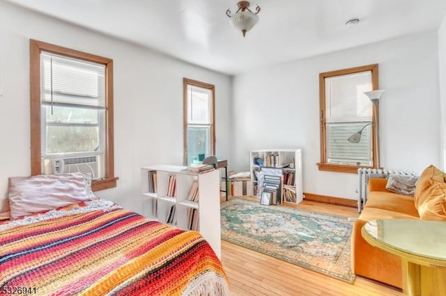 bedroom with hardwood / wood-style floors and cooling unit