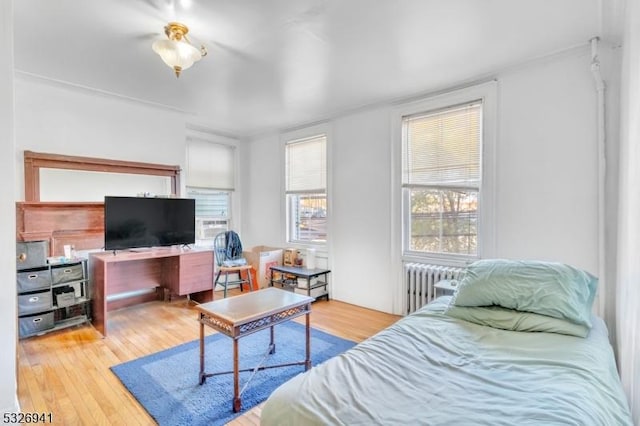 bedroom featuring light hardwood / wood-style floors and radiator heating unit