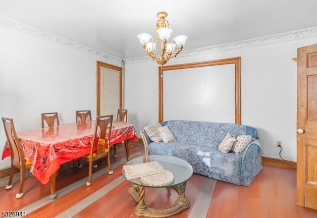 interior space featuring ornamental molding, wood-type flooring, and an inviting chandelier