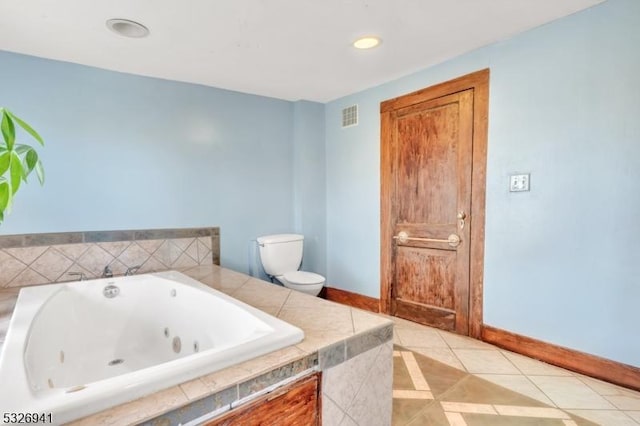 bathroom featuring tile patterned floors, tiled bath, and toilet