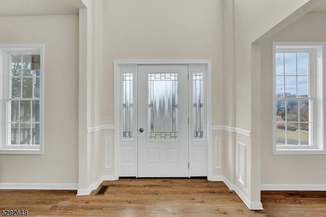 foyer entrance with light wood-type flooring and a wealth of natural light