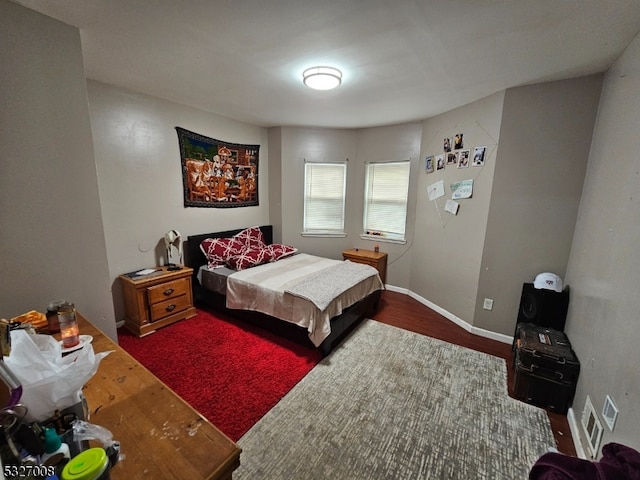 bedroom with dark hardwood / wood-style floors