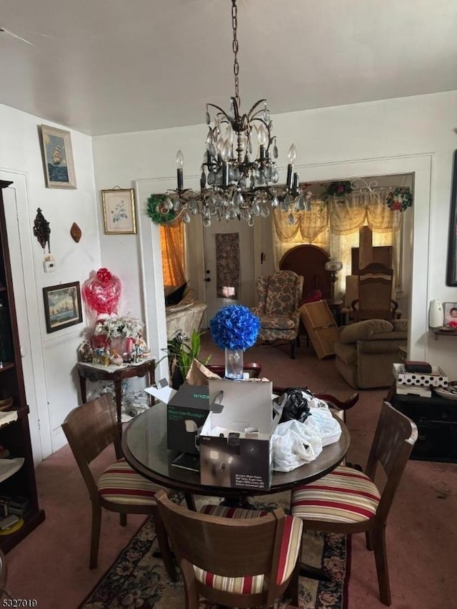 carpeted dining space with a chandelier