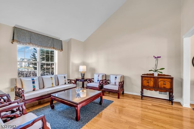 living room featuring vaulted ceiling and light hardwood / wood-style flooring