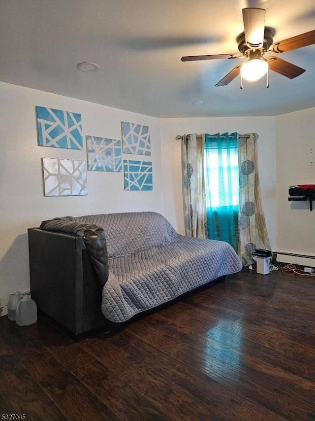 bedroom featuring dark hardwood / wood-style flooring, baseboard heating, and ceiling fan