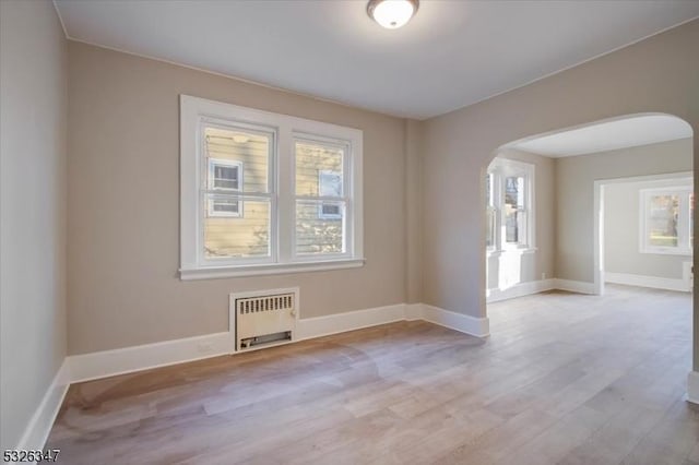 empty room with radiator and light hardwood / wood-style flooring