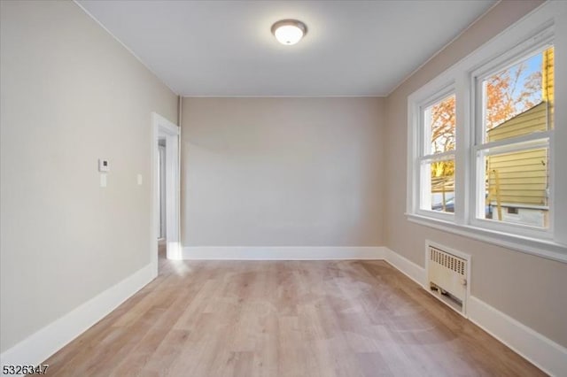 empty room with radiator and light wood-type flooring