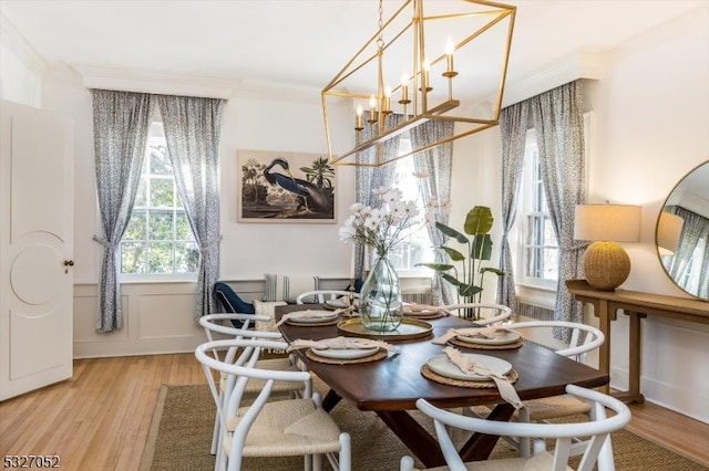 dining room with hardwood / wood-style flooring, a notable chandelier, and ornamental molding