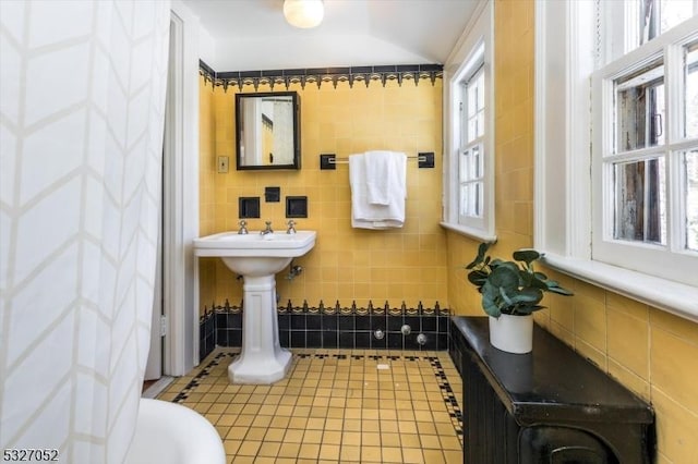 bathroom with tile patterned flooring and tile walls