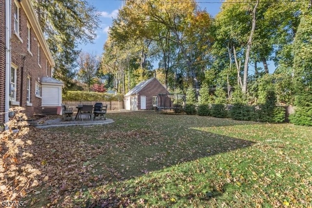 view of yard featuring a patio, a trampoline, and a storage shed