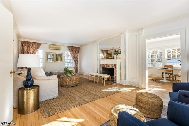 living room with crown molding, hardwood / wood-style flooring, a wall mounted air conditioner, and a premium fireplace