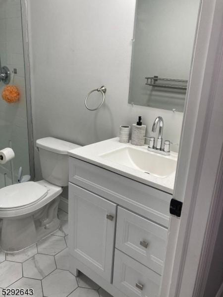 bathroom featuring a shower, vanity, and toilet