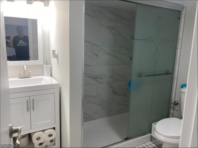 bathroom with tile patterned flooring, a shower with door, vanity, and toilet