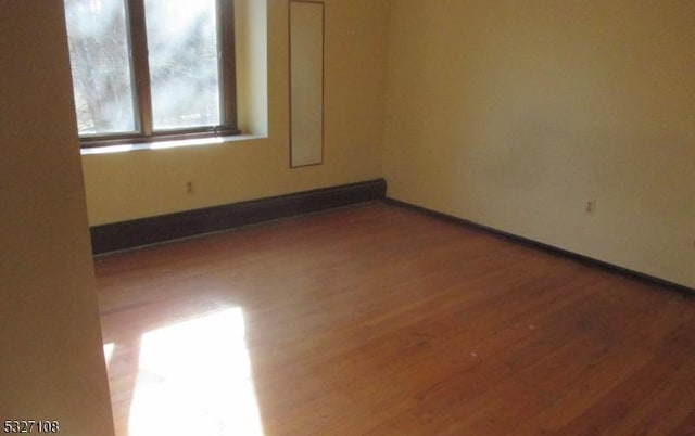 unfurnished room with hardwood / wood-style flooring