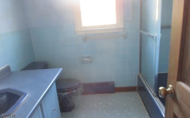 full bathroom with vanity, combined bath / shower with glass door, tile walls, and toilet