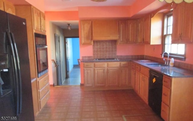 kitchen featuring black appliances, sink, light brown cabinetry, and tasteful backsplash