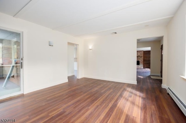 empty room with a fireplace, dark hardwood / wood-style floors, and a baseboard heating unit