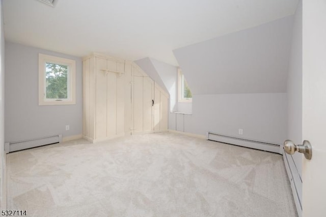 additional living space featuring light carpet, baseboard heating, and lofted ceiling