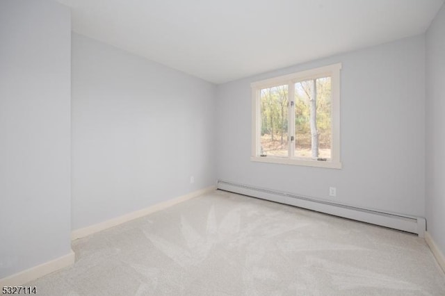 empty room with a baseboard radiator and light colored carpet