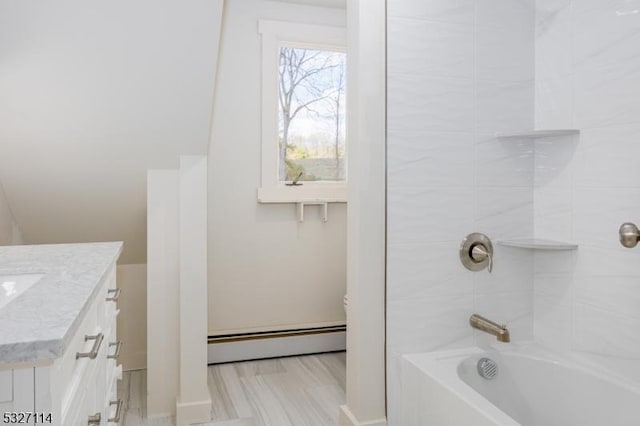 bathroom featuring baseboard heating, vanity, and tiled shower / bath