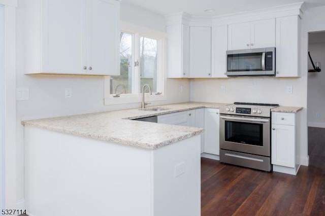 kitchen with dark hardwood / wood-style floors, light stone countertops, white cabinetry, and appliances with stainless steel finishes