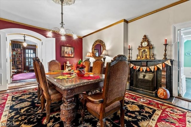 dining space featuring hardwood / wood-style floors, ornamental molding, and a chandelier