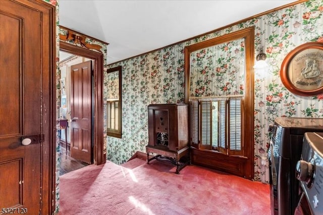 sitting room with carpet floors, vaulted ceiling, and ornamental molding