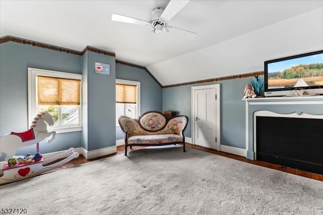 living area with ceiling fan, carpet floors, and vaulted ceiling