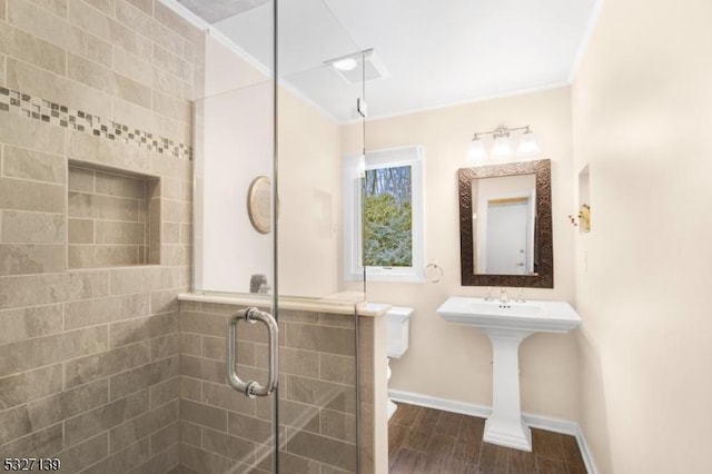 bathroom with ornamental molding, hardwood / wood-style floors, an enclosed shower, and toilet