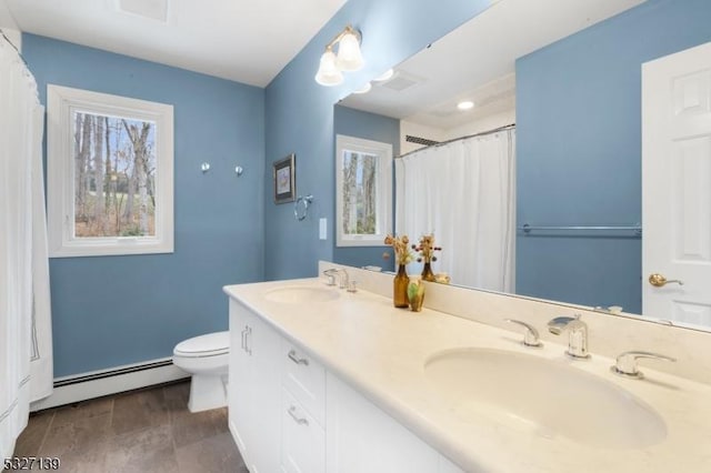 bathroom featuring vanity, plenty of natural light, toilet, and baseboard heating