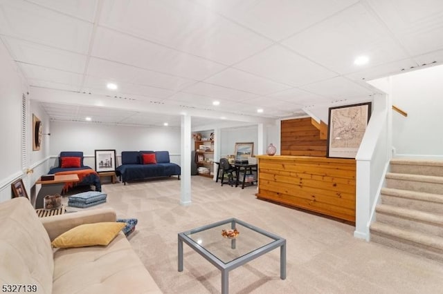 carpeted living room with a paneled ceiling