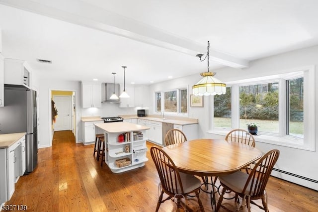 dining space with beamed ceiling, a baseboard heating unit, and dark hardwood / wood-style flooring