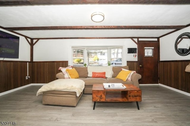 living room featuring beam ceiling, hardwood / wood-style flooring, and wood walls