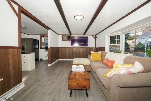 living room with hardwood / wood-style flooring, ornamental molding, and wooden walls