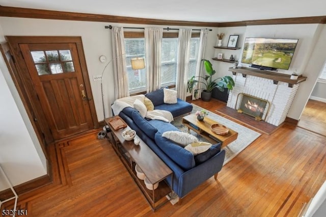 living room featuring a fireplace, hardwood / wood-style flooring, and crown molding