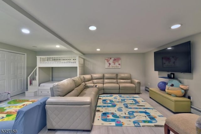 living room featuring a baseboard heating unit and light hardwood / wood-style flooring