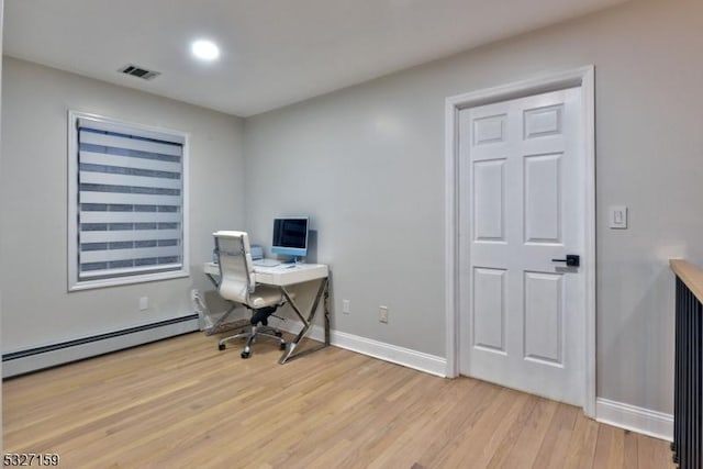 home office with a baseboard heating unit and light wood-type flooring