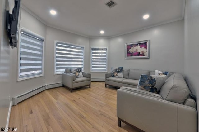 living room with a baseboard radiator, crown molding, and light wood-type flooring