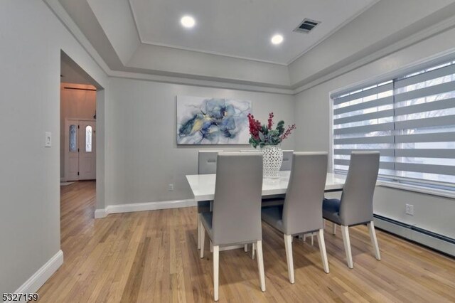 dining room featuring baseboard heating and light hardwood / wood-style flooring